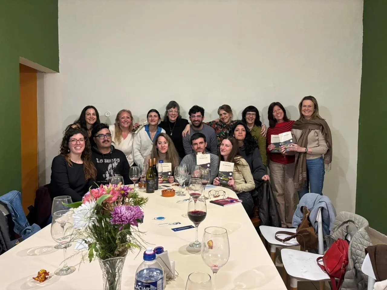 Foto grupal del club de lectura alrededor de la mesa, con los libros en la mano