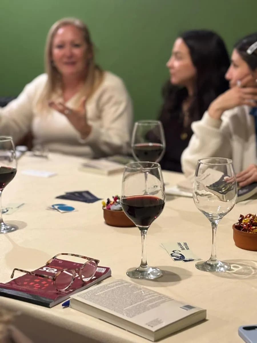 La mesa del encuentro: copas de vino, libros abiertos y anotaciones